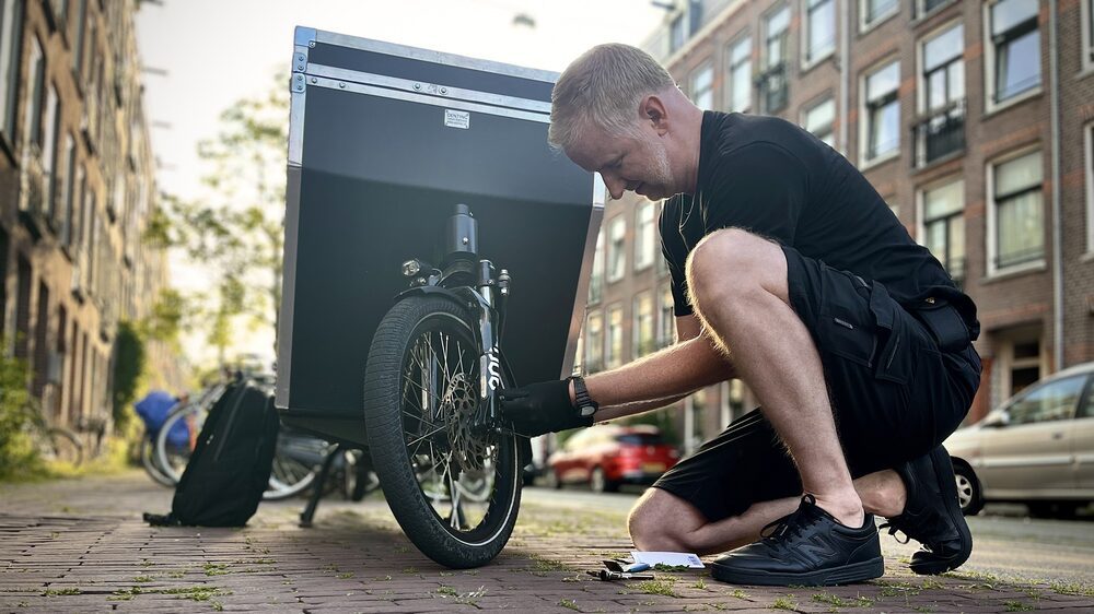 yeply-monteur werkt aan een bakfiets in de straat